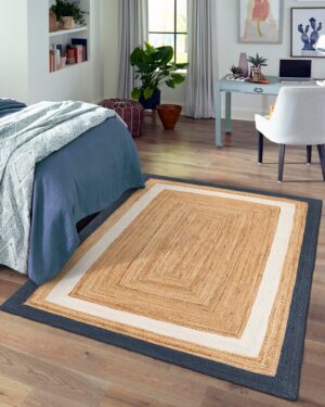 Handmade jute floor rug with blue border placed in elegant indoor space