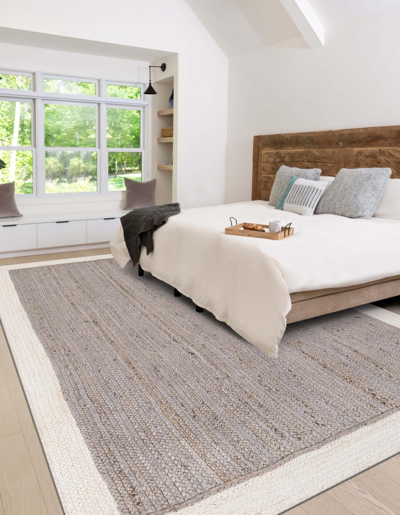 Handwoven Grey & White Jute Area Rug Grey and white jute area rug placed under bed in a bright modern bedroom