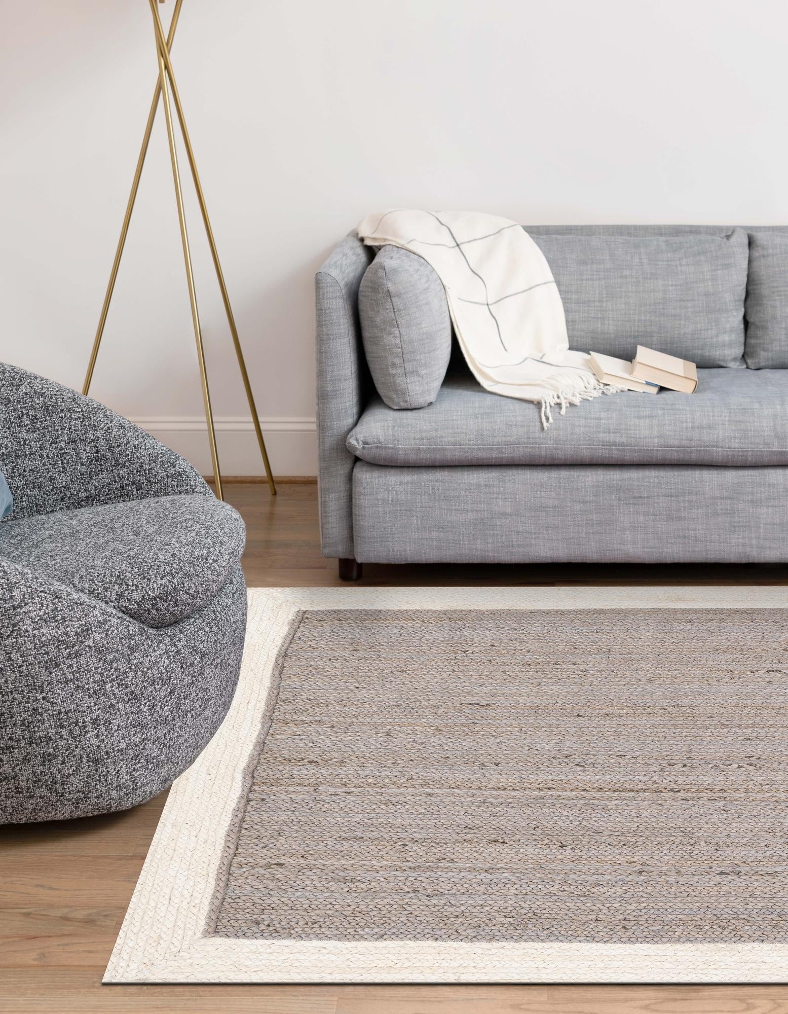 Grey & White Handwoven Jute Area Carpet Rectangular grey and white braided jute rug on hardwood floor beside bed