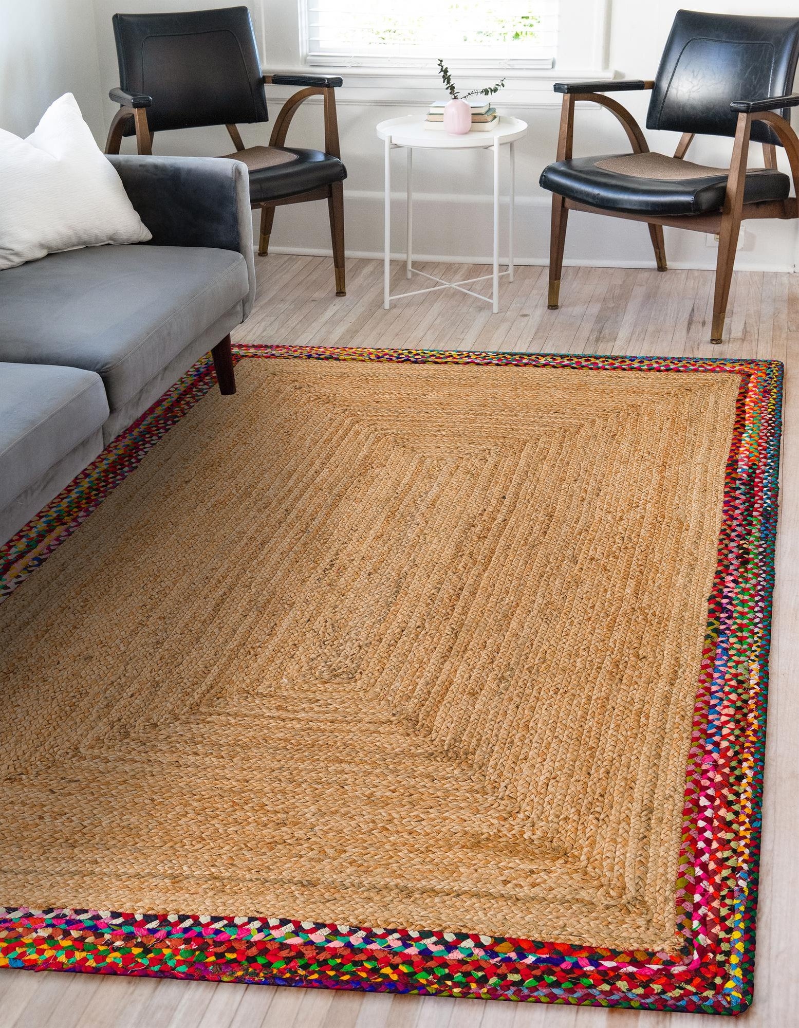 Handwoven Natural Jute Rug with Colorful Border Handwoven natural jute area rug with colorful multicolor border in modern living room