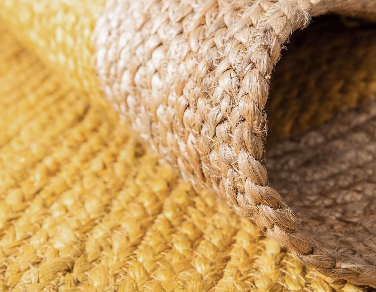 Yellow Center Jute Rug Close-up shows the edge and surface texture of a round jute rug with a golden yellow center and braided natural fiber border.