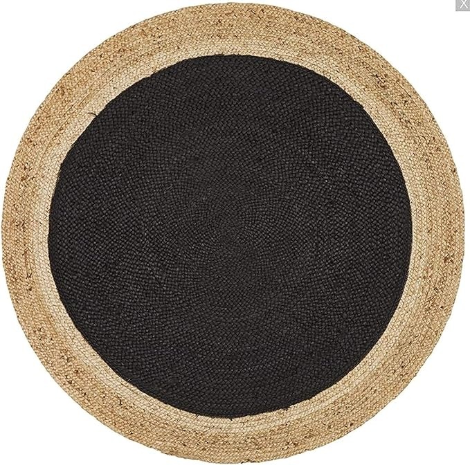 Black and Natural Jute Round Rug Overhead shot of a round, braided jute rug featuring a central black circle surrounded by a natural fiber border.